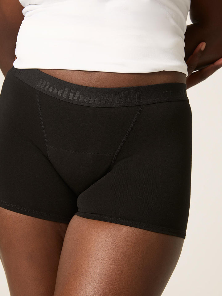 Close up view Modibodi teen hipster boyshort, Super absorbency period underwear black. Super absorbency for heavy periods to overnight wear.